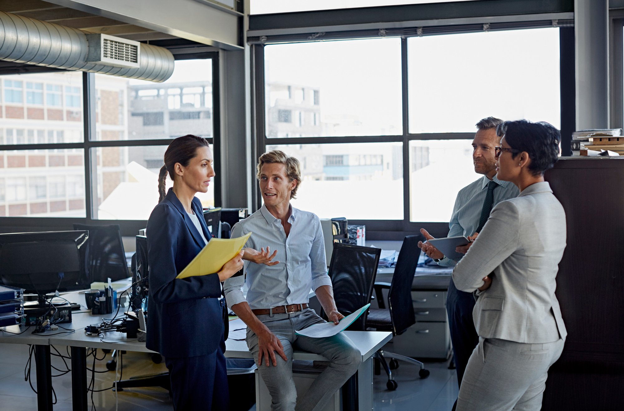 Business people communicating in office GettyImages-1492336870