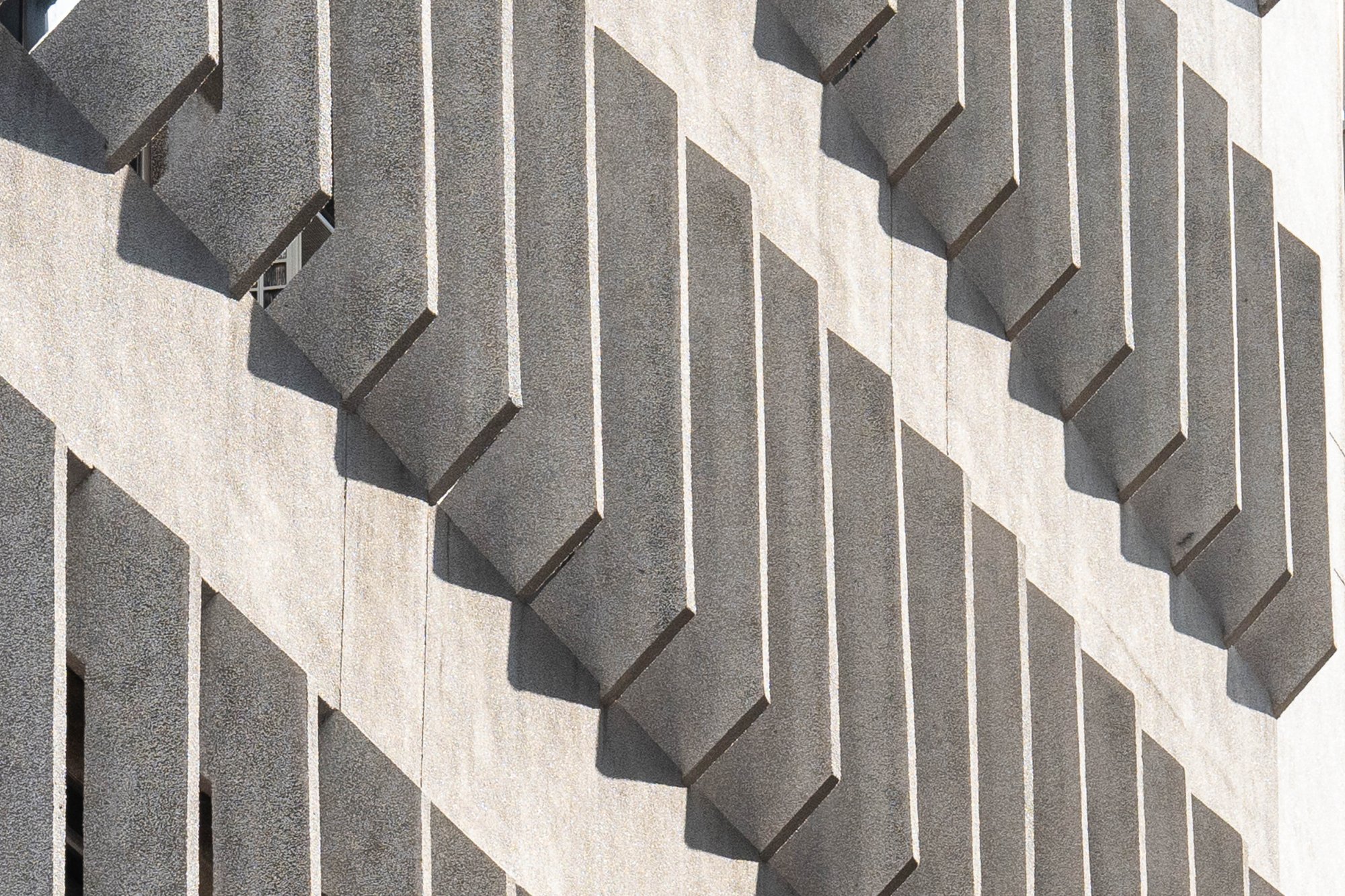 Repeating concrete façade with structured geometric depth.
